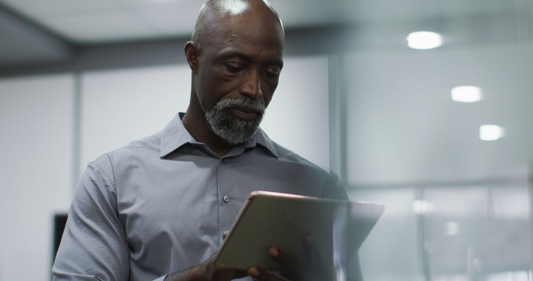 Focused African American Businessman Using Tablet in Office - Free Images, Stock Photos and Pictures on Pikwizard.com