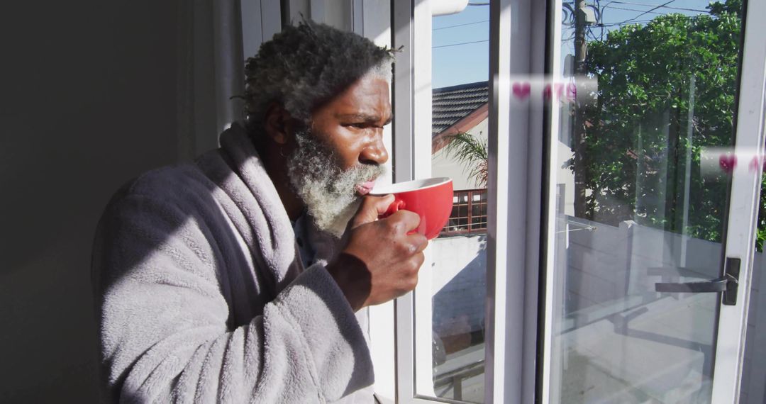 Man in Bathrobe Sipping Coffee by Sunny Window