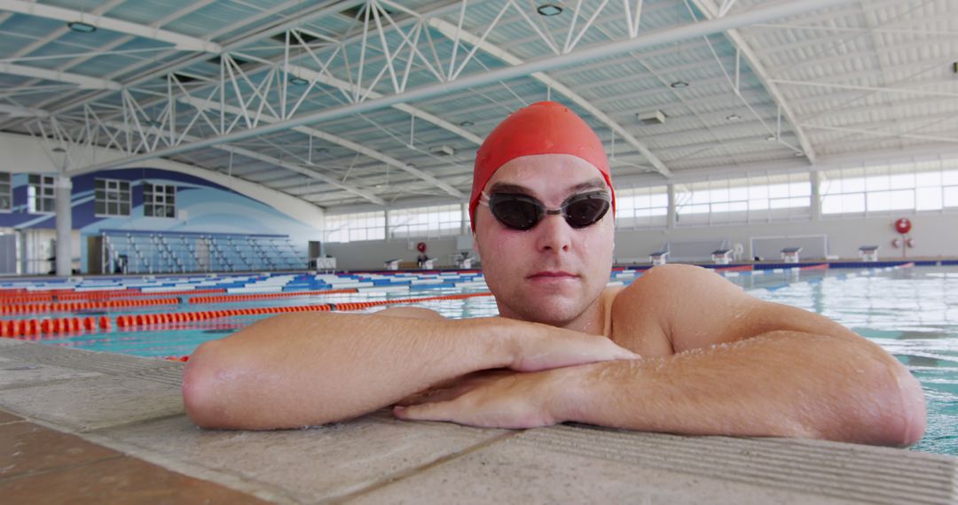 Portrait of caucasian male swimmer in cap and goggles at the side in indoor pool - Free Images, Stock Photos and Pictures on Pikwizard.com
