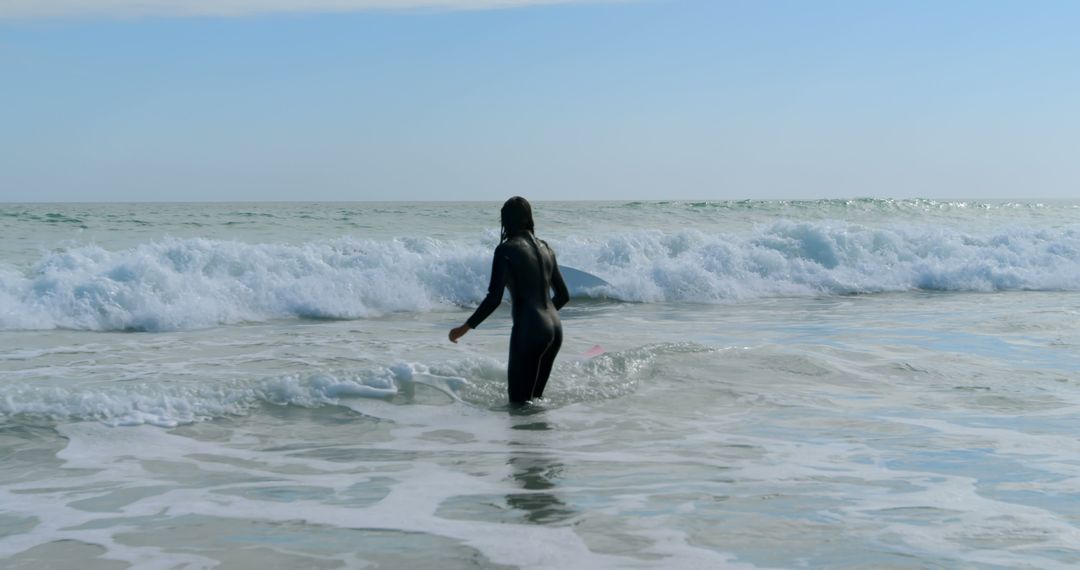 Surfer Wearing Wetsuit Facing Ocean Waves on Sunny Day - Free Images, Stock Photos and Pictures on Pikwizard.com