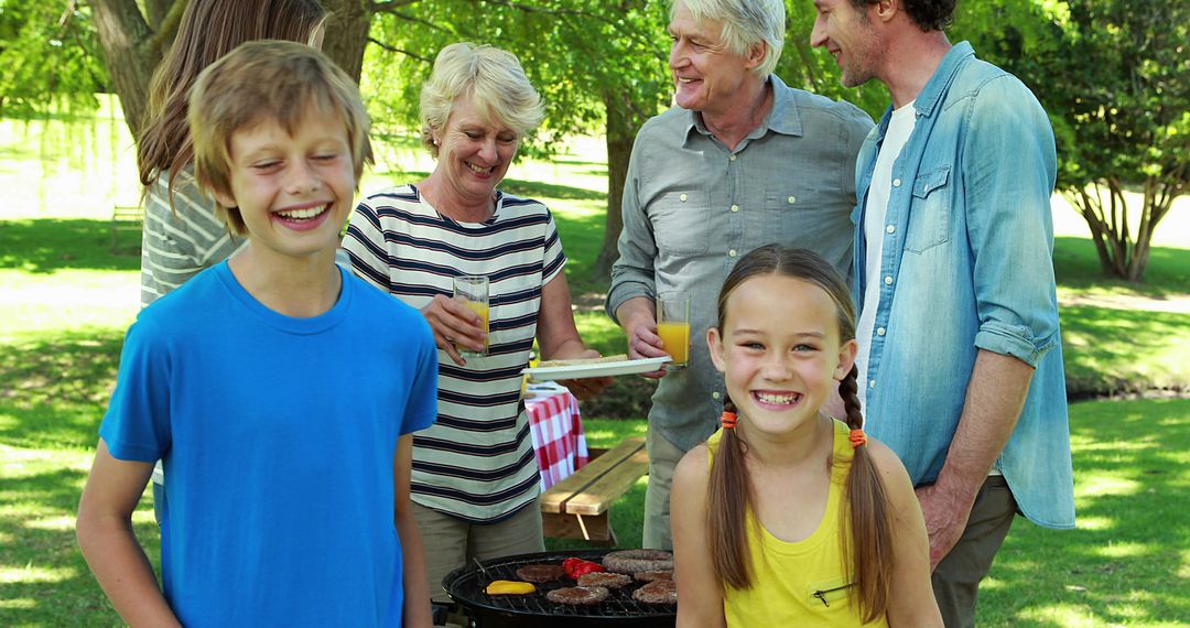 Smiling Family Enjoying a Barbecue in the Park - Free Images, Stock Photos and Pictures on Pikwizard.com