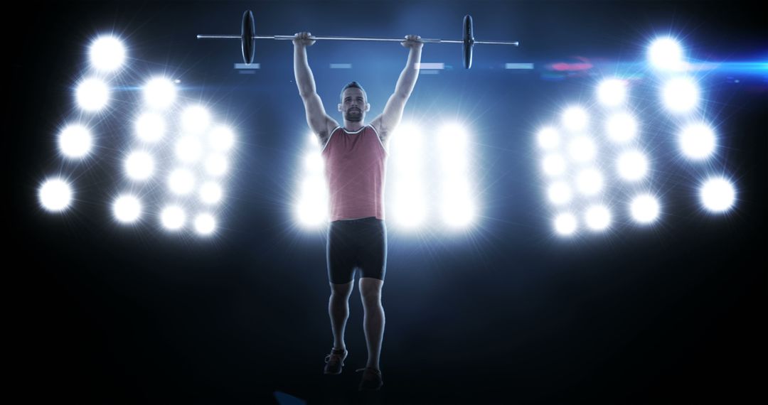 Muscular man lifting barbell overhead in dramatic lighting - Free Images, Stock Photos and Pictures on Pikwizard.com