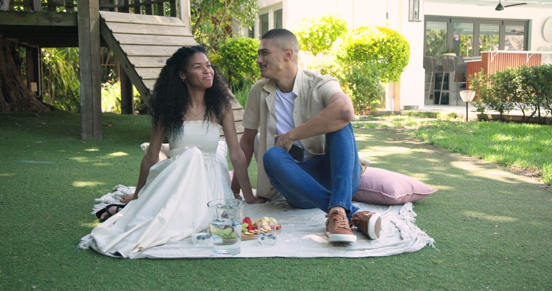 Couple Enjoying Picnic on Blanket in Sunlit Garden