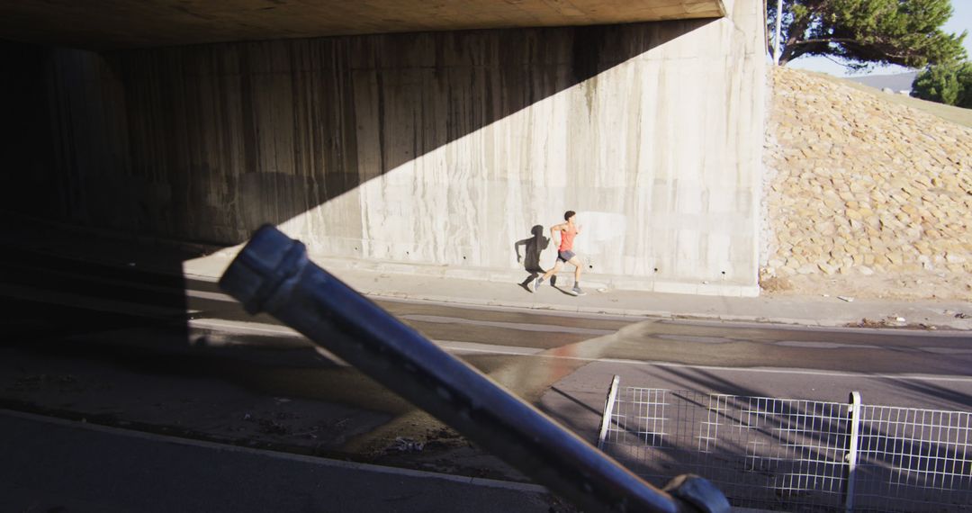 Runner Under Overpass on Sunny Day - Free Images, Stock Photos and Pictures on Pikwizard.com