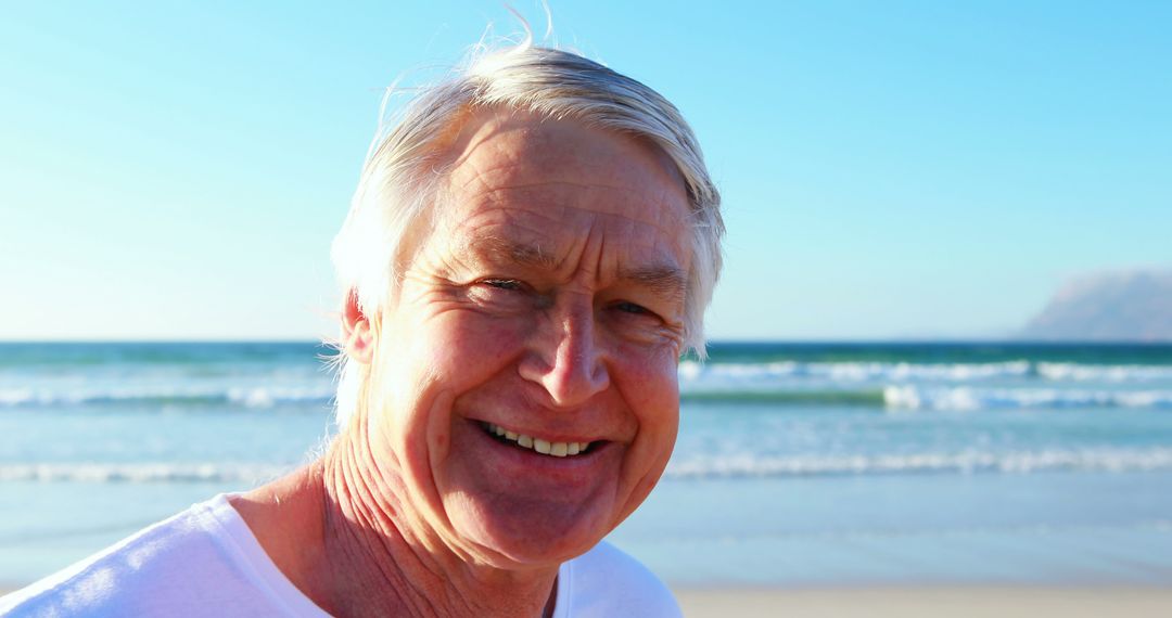 Senior Man Enjoying Sunny Day on Sandy Beach - Free Images, Stock Photos and Pictures on Pikwizard.com