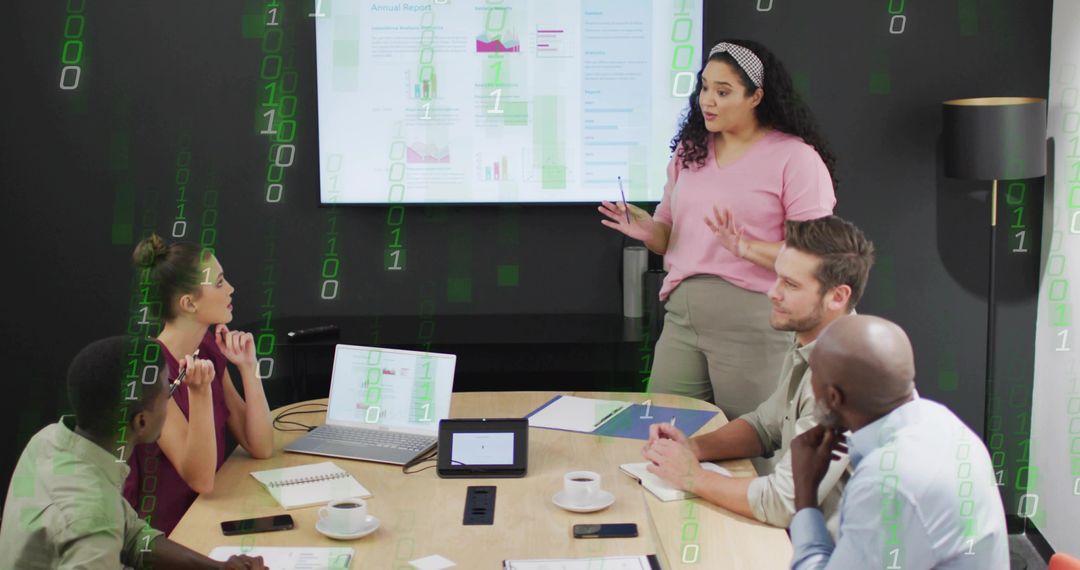 Gesturing presenter leading collaborative business meeting with laptop and data charts