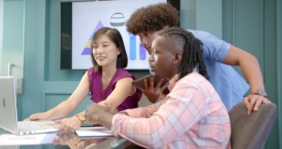 Diverse Team Collaborating with Laptop and Tablet in Office Setting