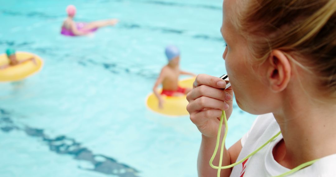 Female Lifeguard Blowing Whistle for Children at Pool - Free Images, Stock Photos and Pictures on Pikwizard.com