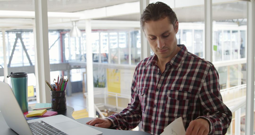 Caucasian Businessman Reviewing Documents in Modern Office Setting