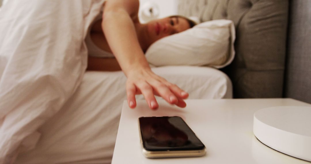 Person Reaching for Smartphone on Bedside Table in the Morning - Free Images, Stock Photos and Pictures on Pikwizard.com