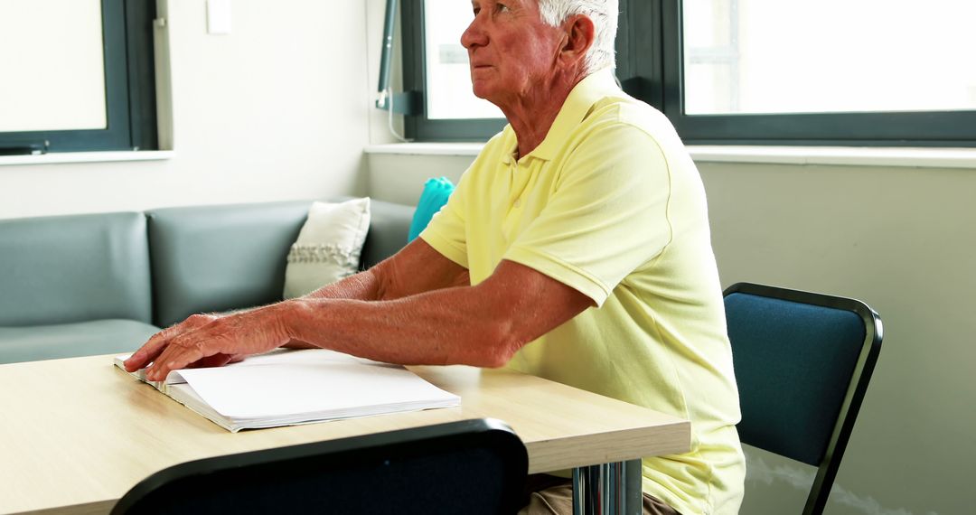 Senior Man Sitting at Table with Document in Daylight - Free Images, Stock Photos and Pictures on Pikwizard.com