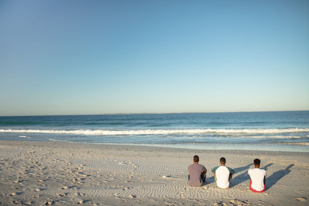 Male friends relaxing together on the beach - Free Images, Stock Photos and Pictures on Pikwizard.com