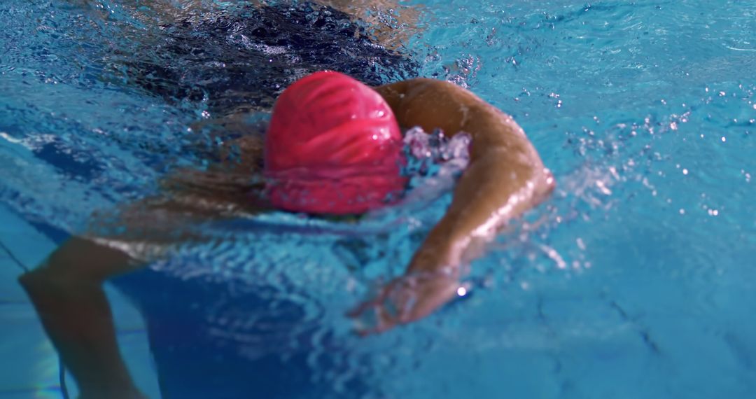 Professional Swimmer in Action with Pink Swim Cap in Pool - Free Images, Stock Photos and Pictures on Pikwizard.com