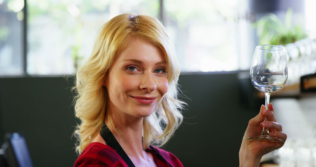 Smiling Waitress Holding Wine Glass in Modern Café