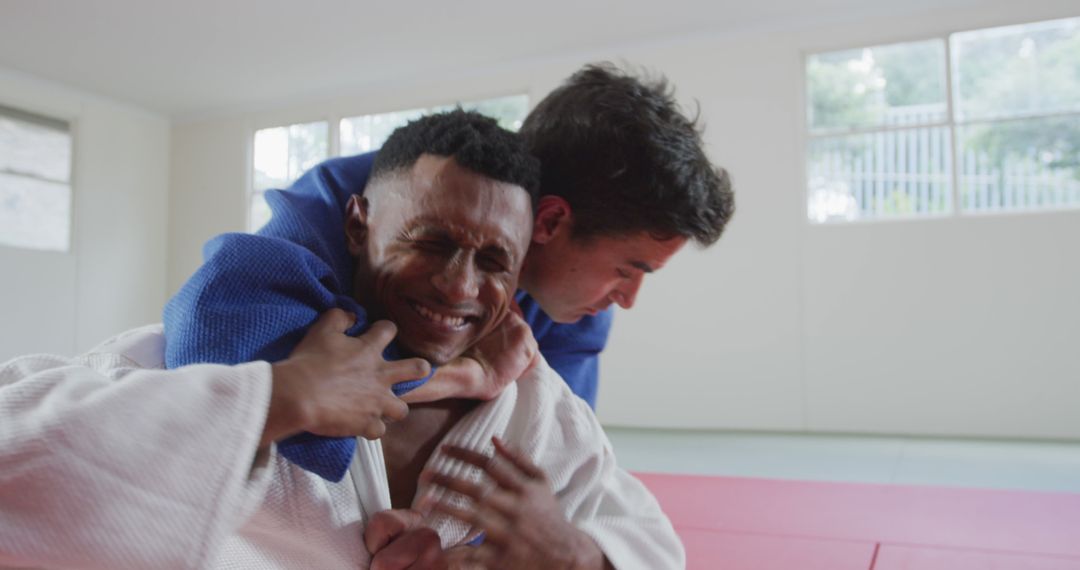 Two Men Practicing Judo Techniques on Red Mats in Studio - Free Images, Stock Photos and Pictures on Pikwizard.com