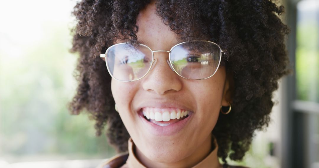 Portrait of happy african american teenager girl wearing glasses, looking at camera and smiling - Free Images, Stock Photos and Pictures on Pikwizard.com