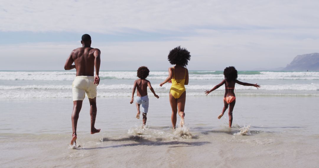 African american parents and two children running at the beach - Free Images, Stock Photos and Pictures on Pikwizard.com