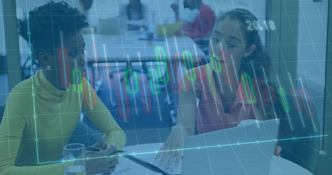 Colleagues Analyzing Stock Data on Laptop in Modern Office Environment