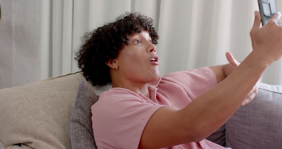 Excited Man Reacting to Smartphone Message at Home