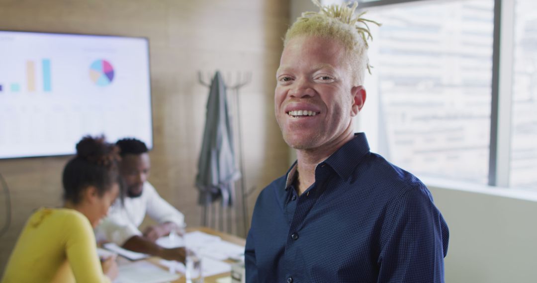 Portrait of happy albino african american businessman with tablet in creative office - Free Images, Stock Photos and Pictures on Pikwizard.com