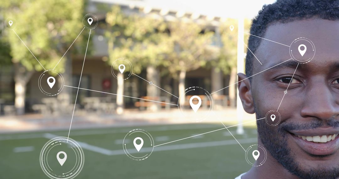 Smiling young man on campus turf with geolocation network overlay and connectivity