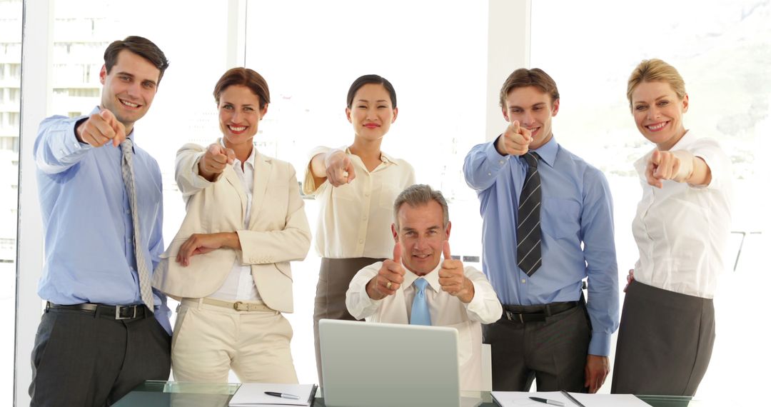 Diverse Business Team Enthusiastically Pointing at Audience in Modern Office