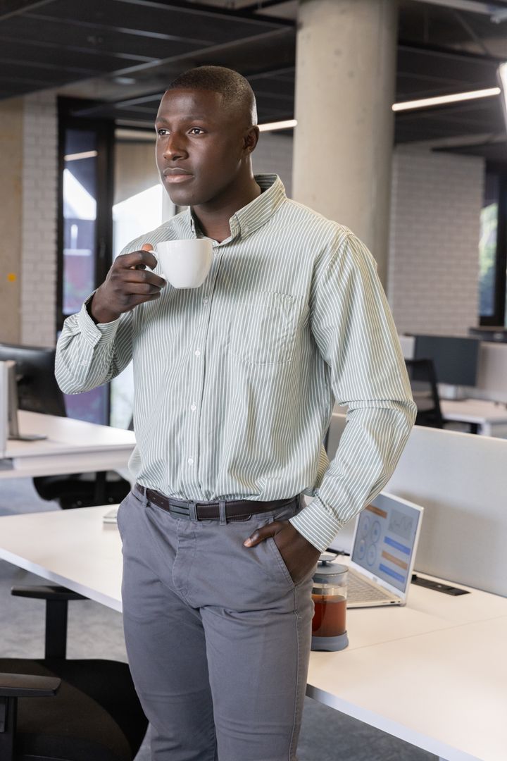 Professional in Modern Office Enjoying Coffee and Analyzing Data