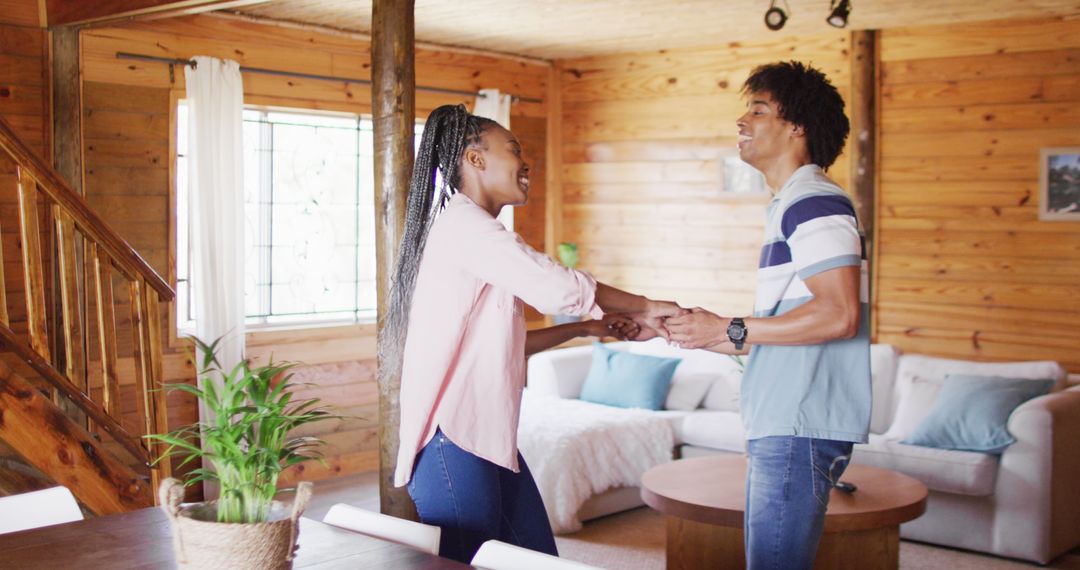 Joyful African American Couple Dancing in Rustic Log Cabin