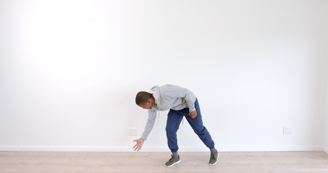 Man Stretching Downward in Minimalist Home Environment