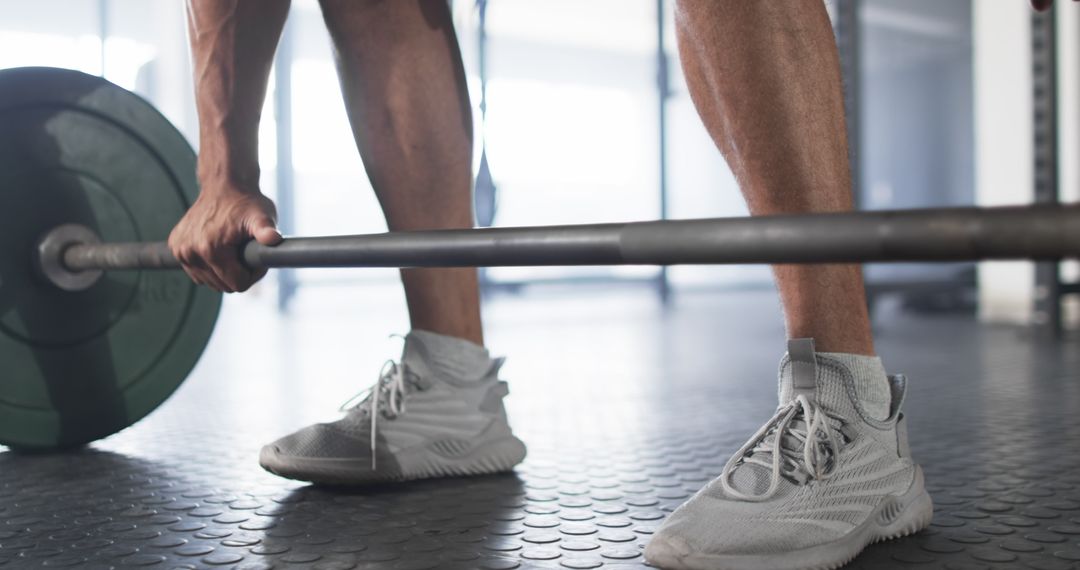Man Lifting Barbell in Gym with Athletic Shoes and Smartwatch