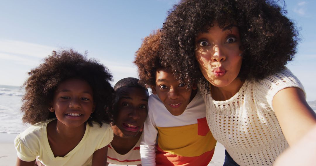African American family enjoys playful selfie time during a beach outing. - Free Images, Stock Photos and Pictures on Pikwizard.com