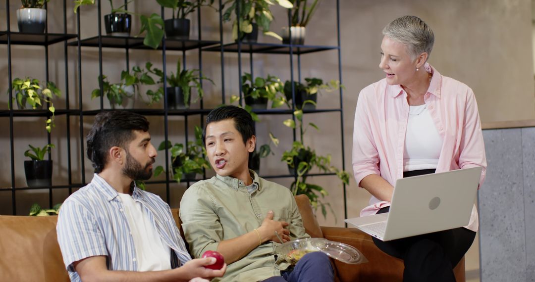 Diverse Team Collaborating in Modern Office Lounge by Plant Shelf