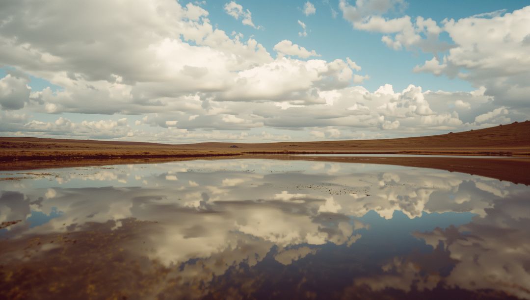 Reflective Shallow Lake Surface Under Cloudy Open Sky