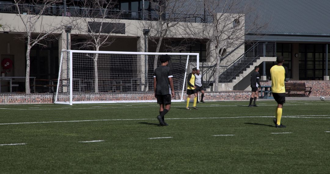 Soccer Players in Yellow Uniforms Practicing on School Field