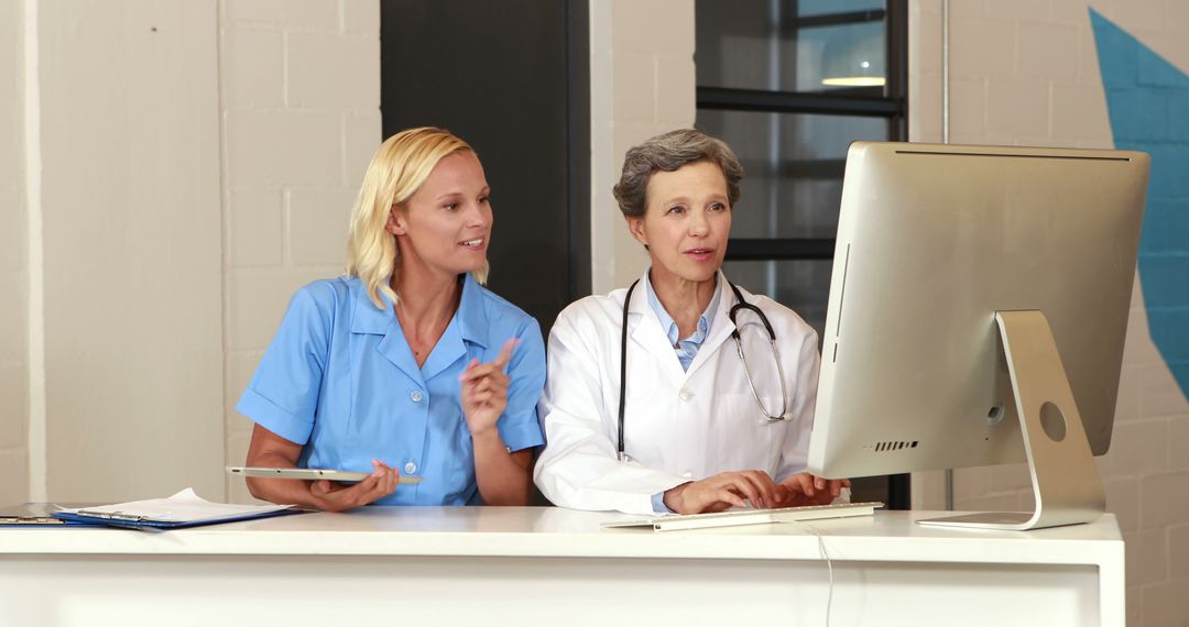 Doctors Discussing Medical Records on Computer in Hospital Office - Free Images, Stock Photos and Pictures on Pikwizard.com