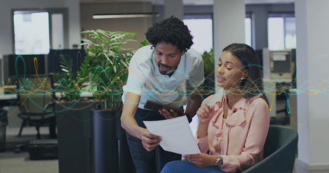 Office Professionals Collaborating on Document in Modern Workspace