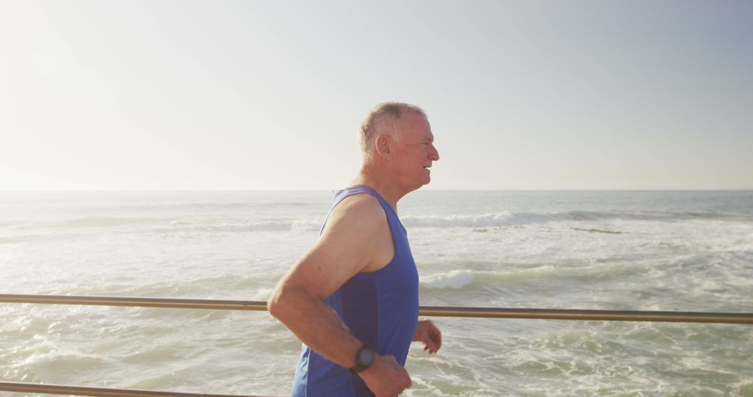 Senior Man Jogging by Ocean in Morning Sunlight - Free Images, Stock Photos and Pictures on Pikwizard.com