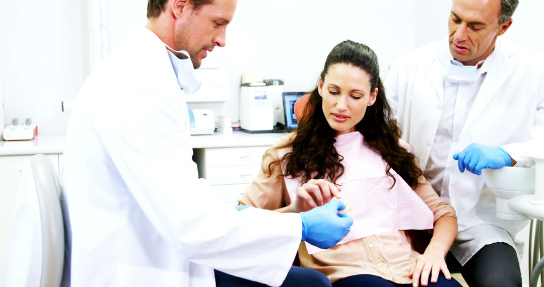 Dentists Consulting with Female Patient in Dental Clinic - Free Images, Stock Photos and Pictures on Pikwizard.com