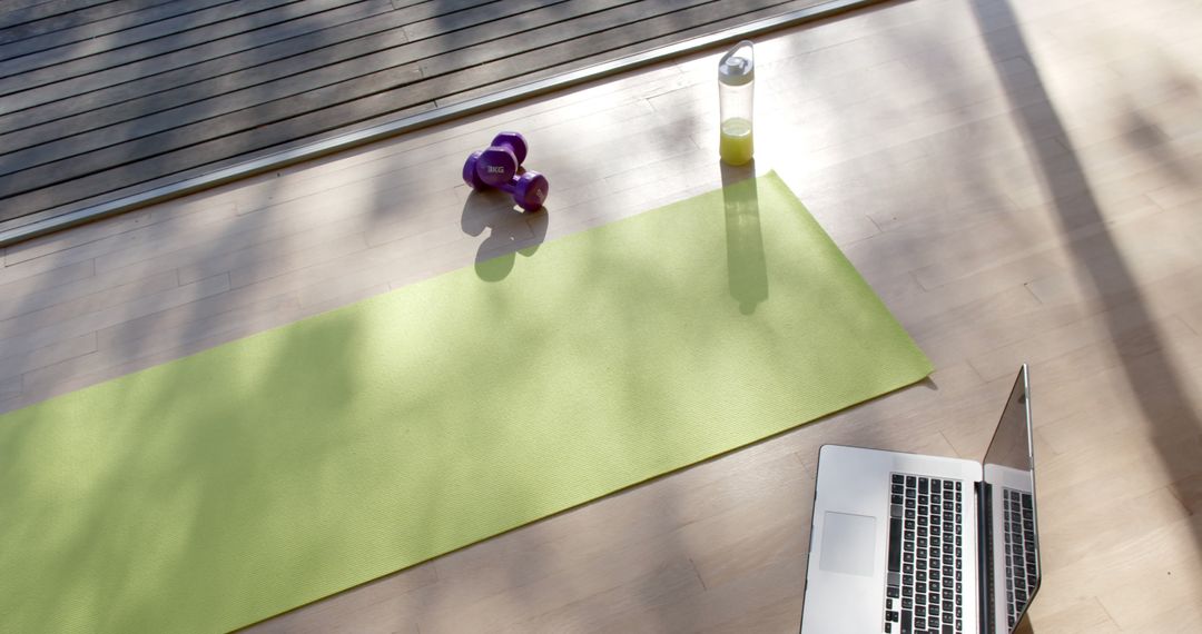 Home Workout Setup with Yoga Mat, Laptop, Dumbbells and Water Bottle - Free Images, Stock Photos and Pictures on Pikwizard.com