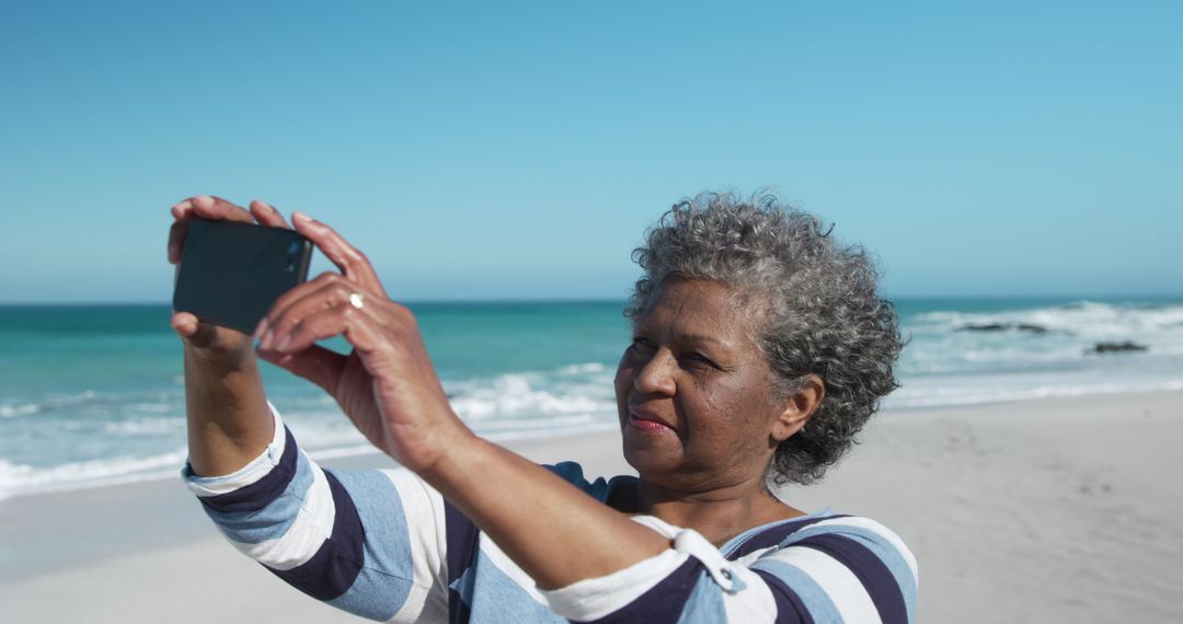 Happy Senior Woman Taking a Selfie on the Beach - Free Images, Stock Photos and Pictures on Pikwizard.com