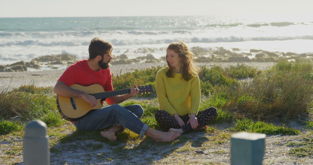 Couple Sitting by Ocean Enjoying Guitar Music Outdoors - Free Images, Stock Photos and Pictures on Pikwizard.com