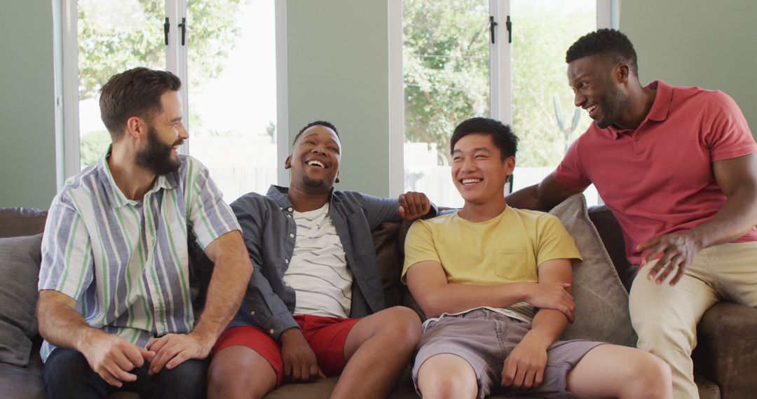 Multiethnic Group of Friends Laughing Together on Couch in Living Room - Free Images, Stock Photos and Pictures on Pikwizard.com