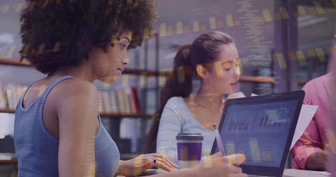 Diverse Team Collaborating in Modern Office with Laptops and Reports