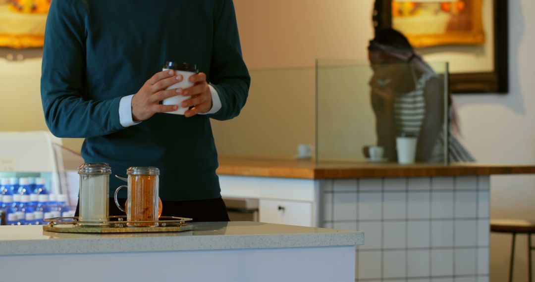 Man Holding Coffee Cup in Cozy Coffee Shop Interior - Free Images, Stock Photos and Pictures on Pikwizard.com