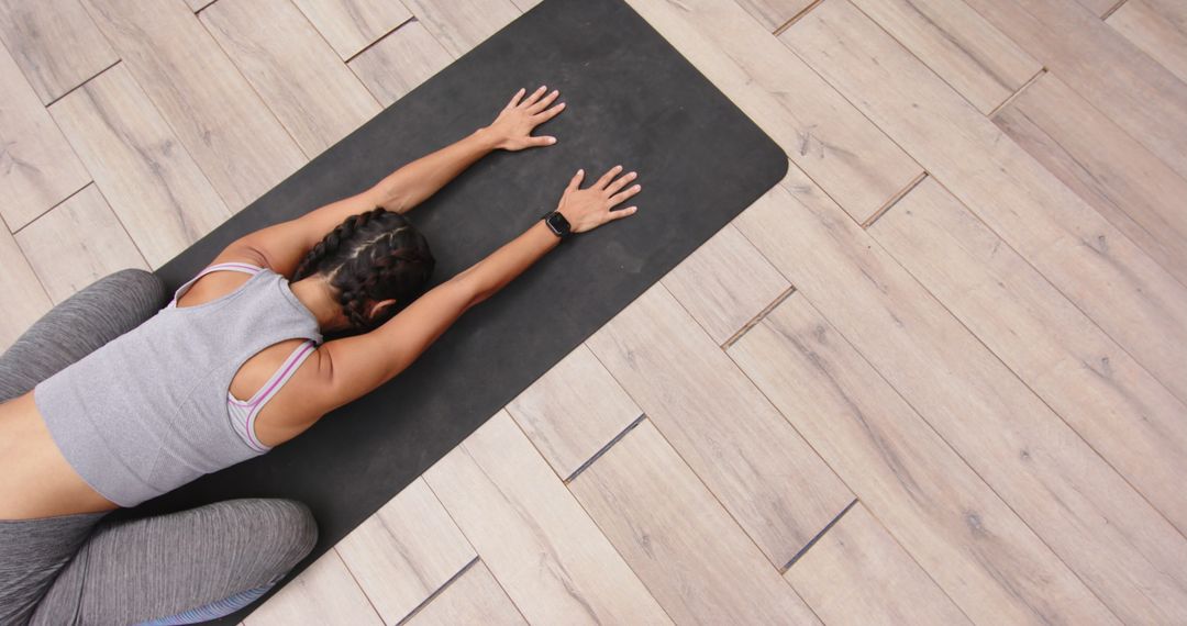 Woman Practicing Child's Pose on Yoga Mat for Relaxation and Flexibility