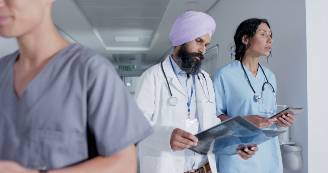 Diverse Medical Team Analyzing Patient X-Ray in Hospital Corridor - Free Images, Stock Photos and Pictures on Pikwizard.com