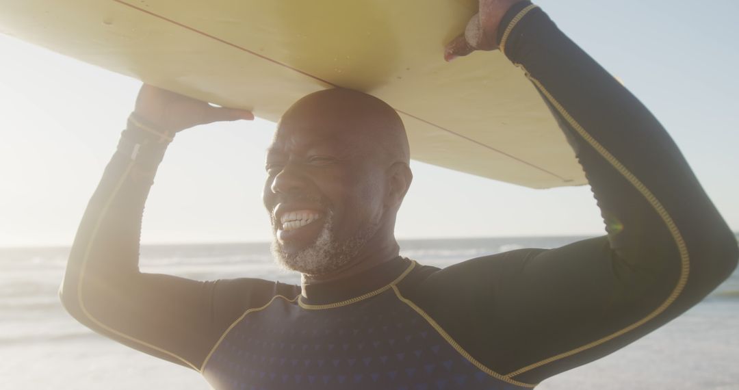 Senior Man Carrying Surfboard on Beach at Sunset - Free Images, Stock Photos and Pictures on Pikwizard.com