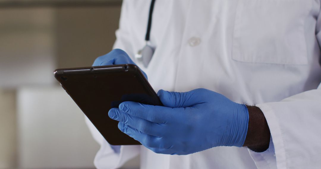 Doctor Wearing Blue Gloves Using Tablet - Free Images, Stock Photos and Pictures on Pikwizard.com