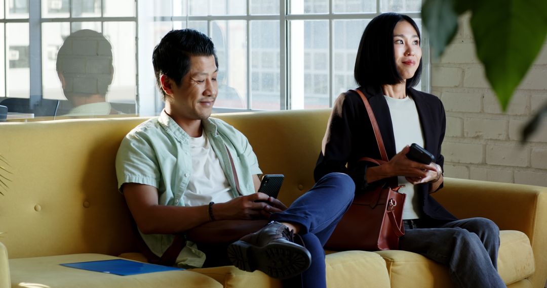 Diverse Colleagues Engaged in Business Brainstorm Session on Yellow Couch