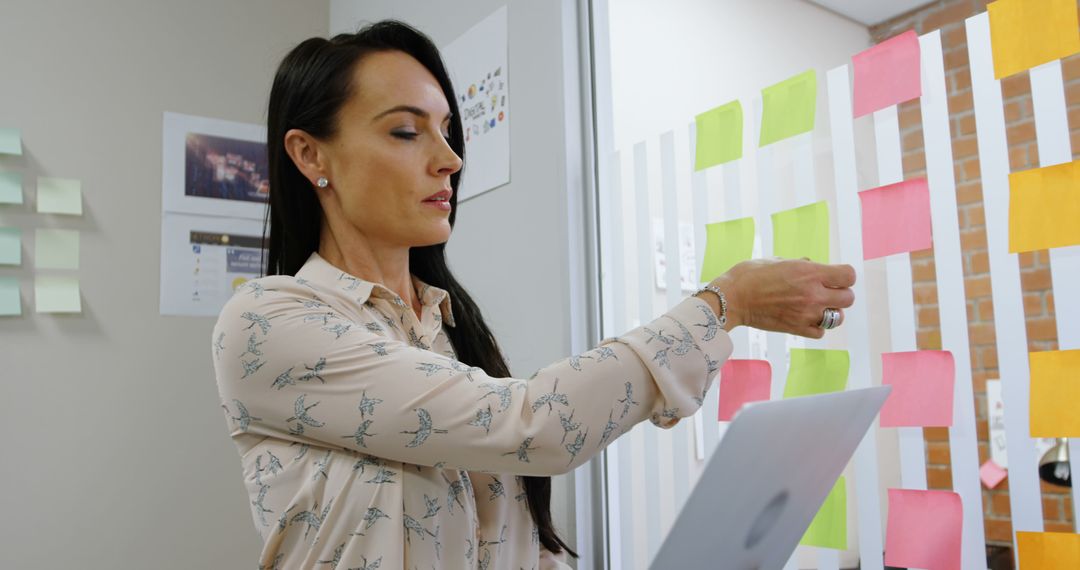 Businesswoman Organizing Sticky Notes in Office - Free Images, Stock Photos and Pictures on Pikwizard.com